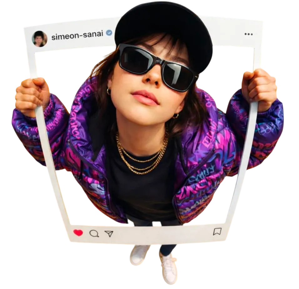 Una creadora con gorra y gafas oscuras sostiene un marco de publicación de Instagram frente a la cámara.